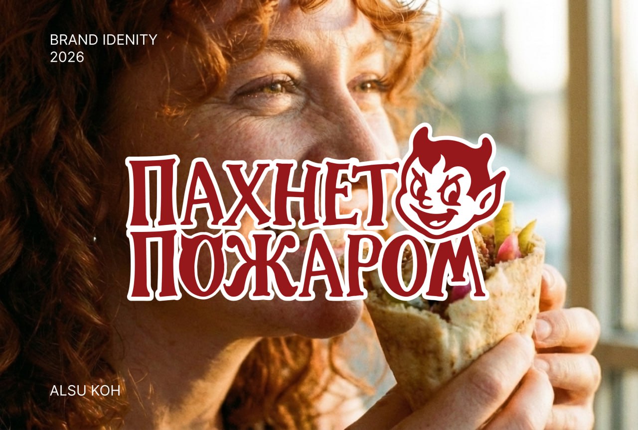 Рыжеволосая женщина с веснушками ест шаурму на фоне надписи «Пахнет пожаром» и дьяволёнка